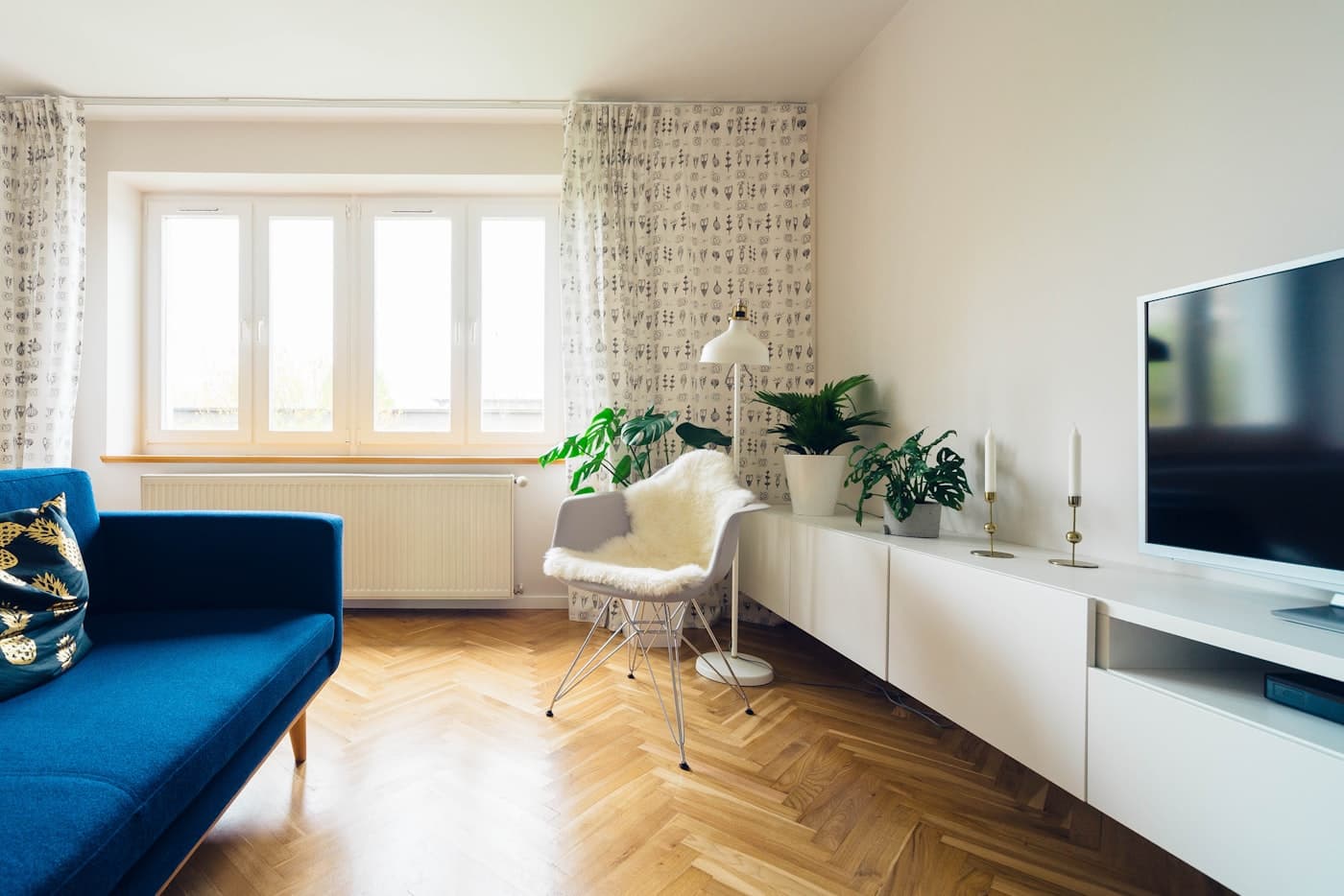An unoccupied apartment living room, curtains open and furniture in place.